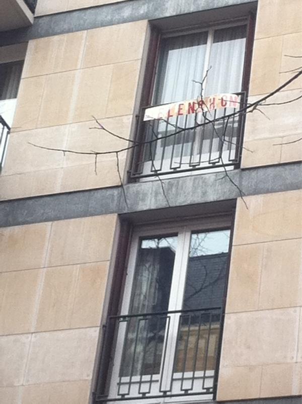 Sarkozy inaugure son QG de campagne, le voisin du dessus accroche une banderole "Melenchon"